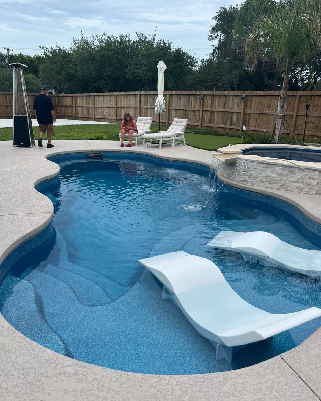 A real Kinetic freeform fiberglass pool with a tanning ledge and in-pool loungers